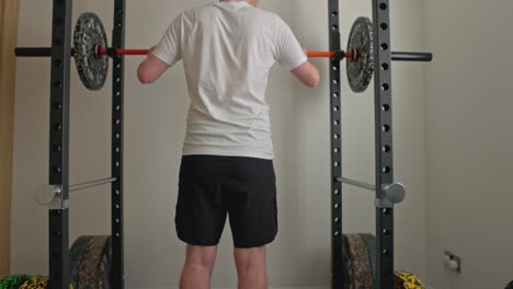 static shot of a young man setting the bar ready for barbell squats