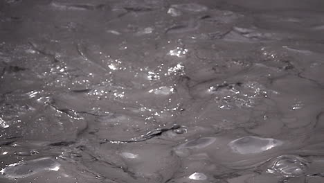 turbulent mud glistens in sunlight in slow motion