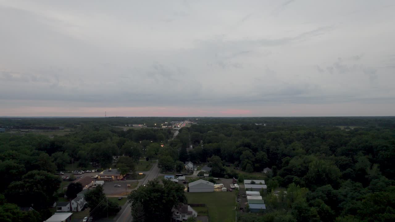 una vista aérea de un pequeño pueblo en el campo al atardecer