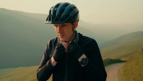 cyclist adjusting helmet and gear in a scenic mountain setting
