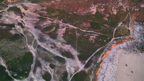 vista aérea de una zona rocosa y de caminos en una costa