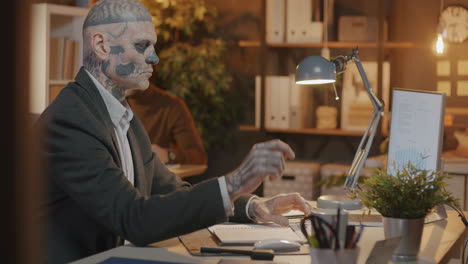 man with skull makeup working in office