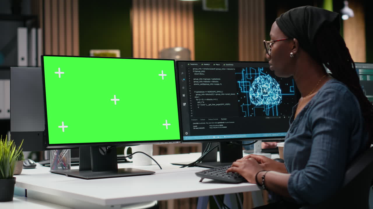 African American Woman Programmer Working on Green Screen Monitor
