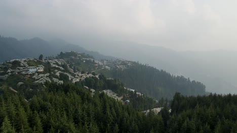 aerial shot of a lake covered in between green trees. captured during sunset in himachal pradesh.