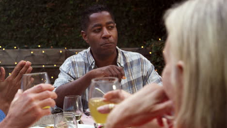 Mature-Friends-Enjoying-Outdoor-Meal-In-Backyard-Shot-On-R3D