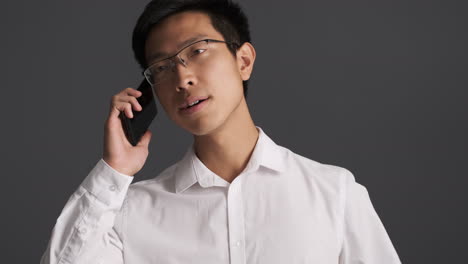 un hombre asiático preocupado llamando por teléfono.