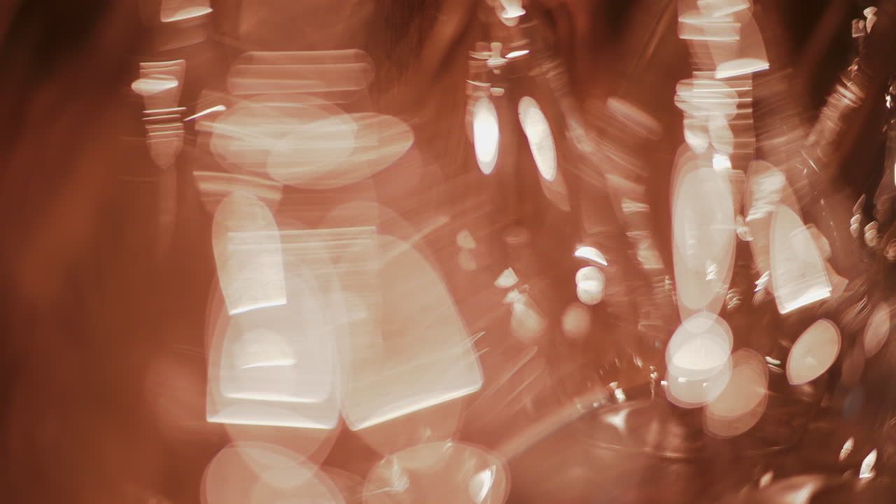 Close up view of multiple glass vessels softly illuminated with warm light that creates a golden bokeh effect in the background