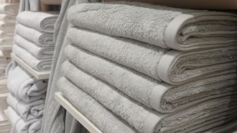 stacked gray and white towels on shelves