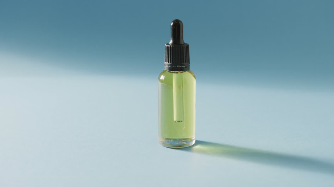 cerca de la botella de vidrio con bomba con espacio de copia en fondo azul