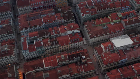 Close-up-rotating-overhead-birds-eye-aerial-view-of-colorful-houses-with-red-rooftops-in-traditional-old-urban-city-center-of-Lisbon,-Portugal