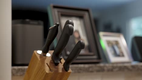 a man replacing a large and skinny knife back into the block.