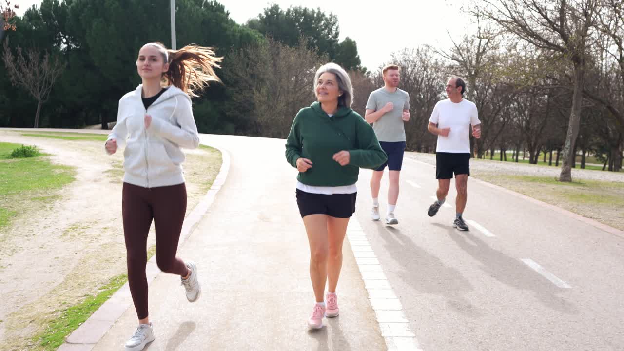 Gruppo eterogeneo di persone che corrono e fanno jogging in un parco