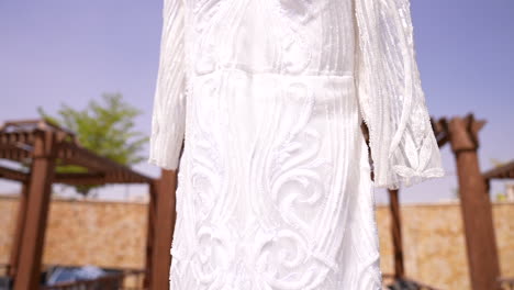 the bride's dress hanging among the plants in the garden