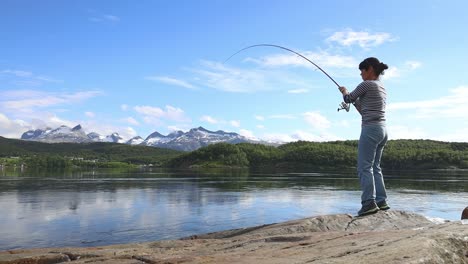 woman fishing on fishing rod spinning in norway.