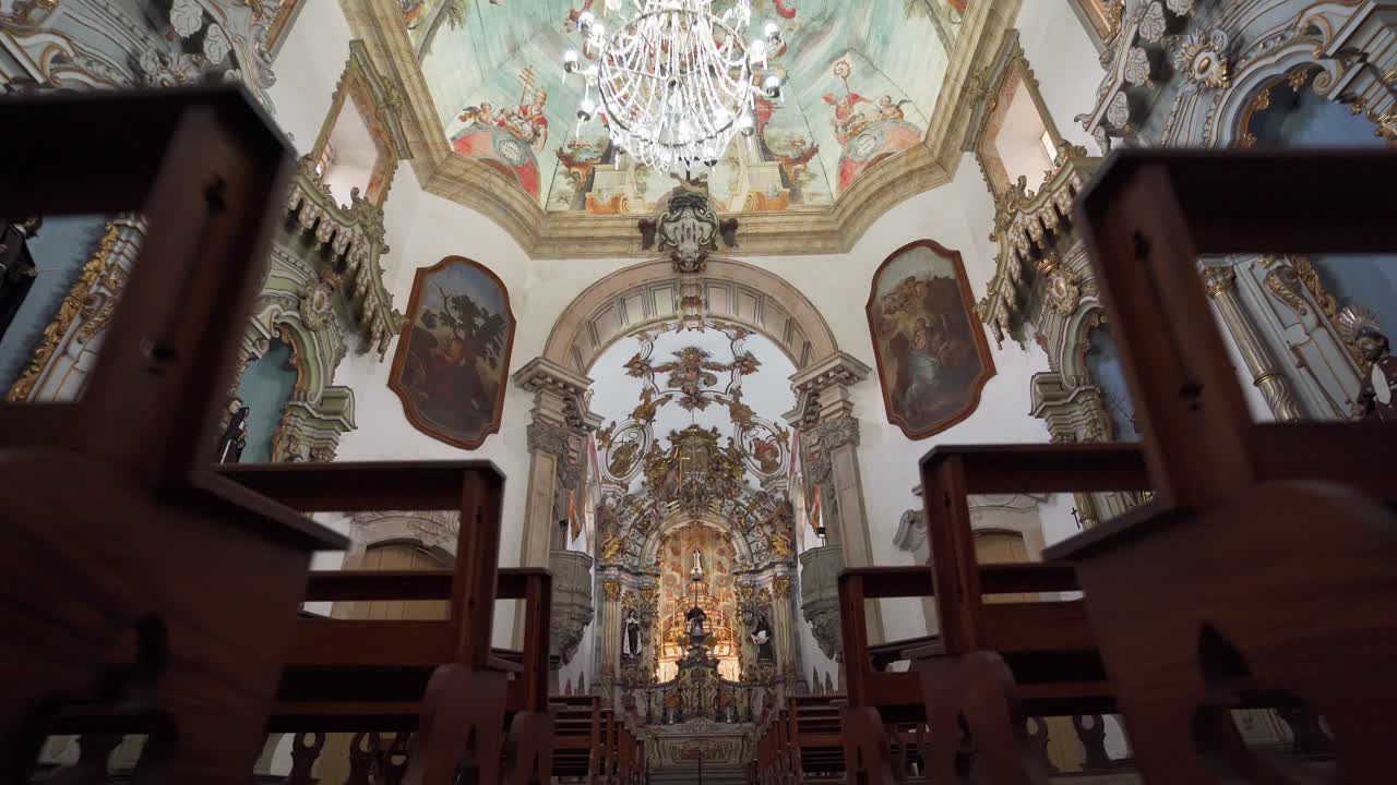 Wide low-angle push-in shot showcasing the interior of the Church of Saint Francis of Assisi, with a focus on the altar and its elaborate details in Ouro Preto, Brazil (Minas Gerais, Brasil)