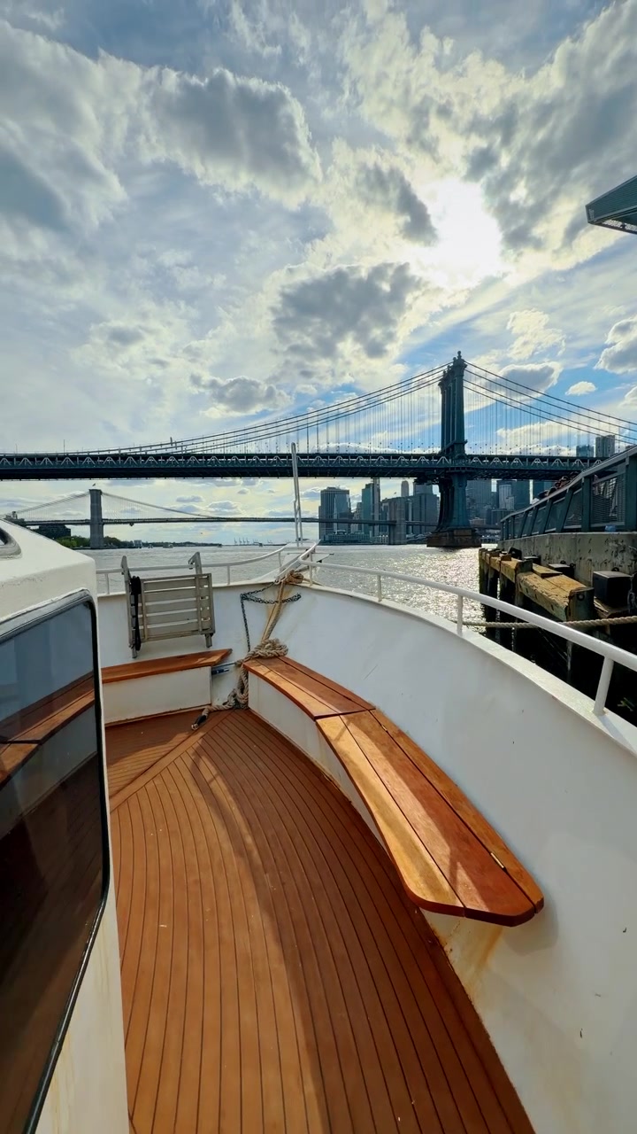 Blick vom Bootsdeck, das am Pier mit der Manhattan Bridge liegt. Eine Perspektivaufnahme vom Deck eines Sightseeing-Boots mit Blick auf die Manhattan Bridge und den East River