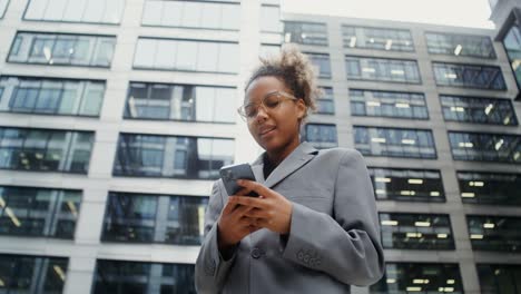 young professional woman using smartphone in city