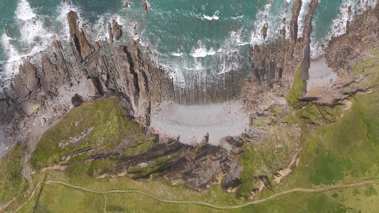 Aerial View of Rugged Coastline with Rocky Cliffs and Crashing Waves
