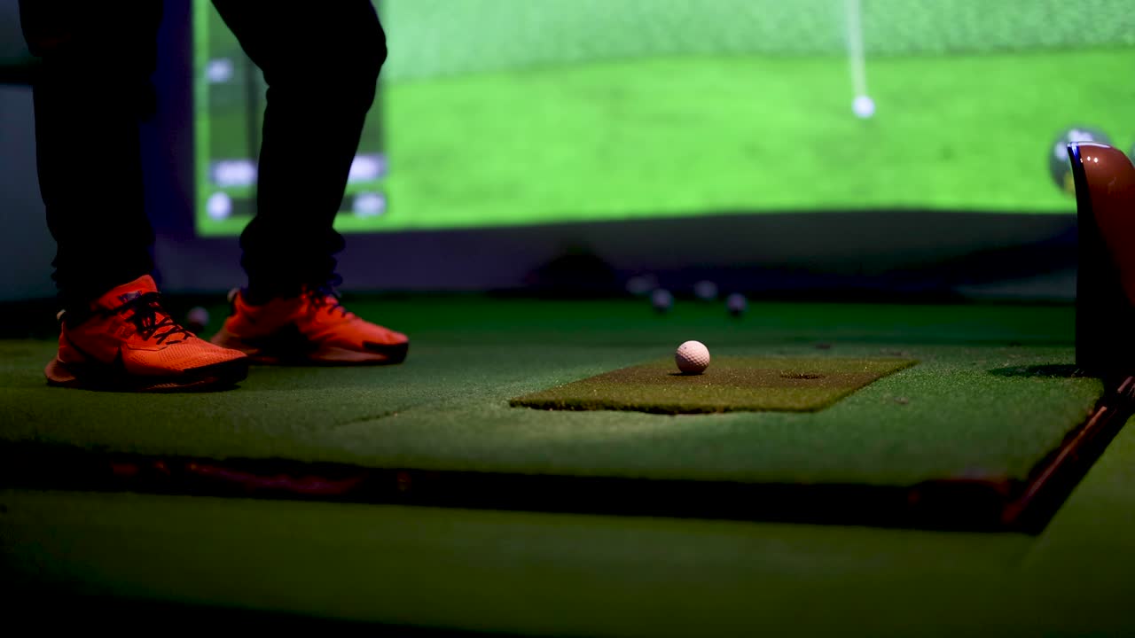 Golfista che pratica lo swing in un simulatore indoor