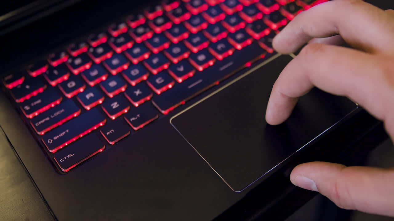 hombre que usa el panel táctil en la computadora portátil