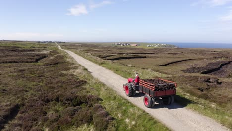 drone shot following a tractor full of peat