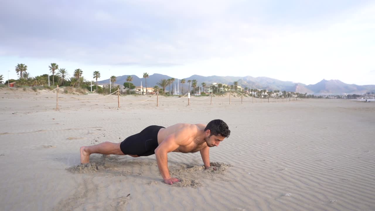 metabolic workout on the beach with variant of lateral push-ups at sunrise