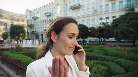 Retrato-De-Una-Alegre-Mujer-De-Negocios-Hablando-Por-Teléfono-Móvil-En-Un-Paseo-Por-La-Ciudad.