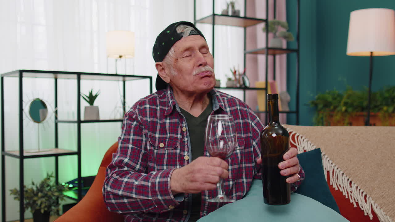 hombre de edad avanzada sonriente bebiendo una copa de vino rojo celebrando el aniversario de su cumpleaños ganando la lotería