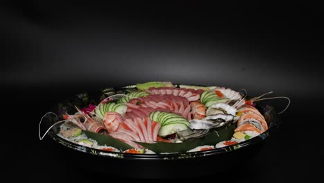 sushi assortment revealed on rotating platter.