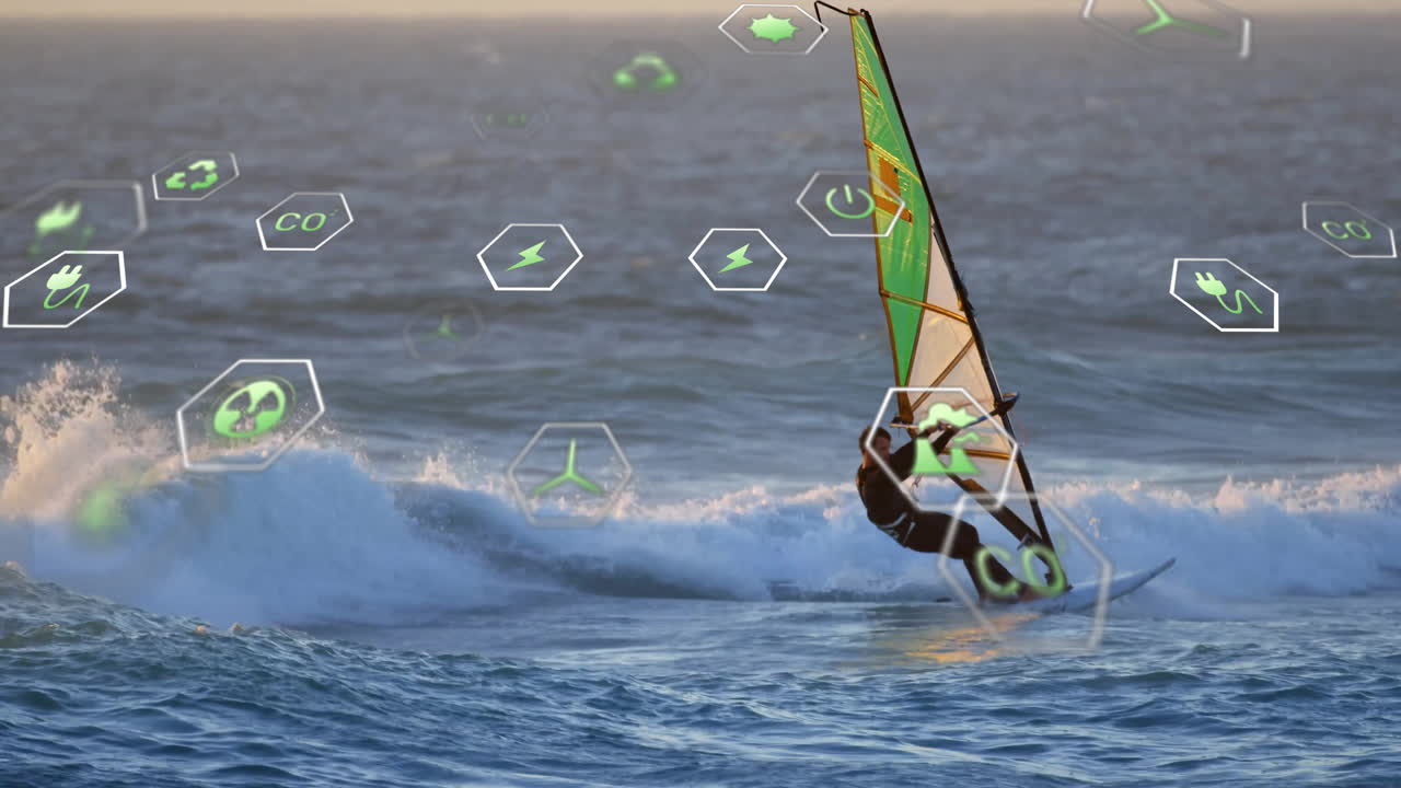 Man wearing wetsuit windsurfing on ocean at sunset, displaying green renewable energy icons around