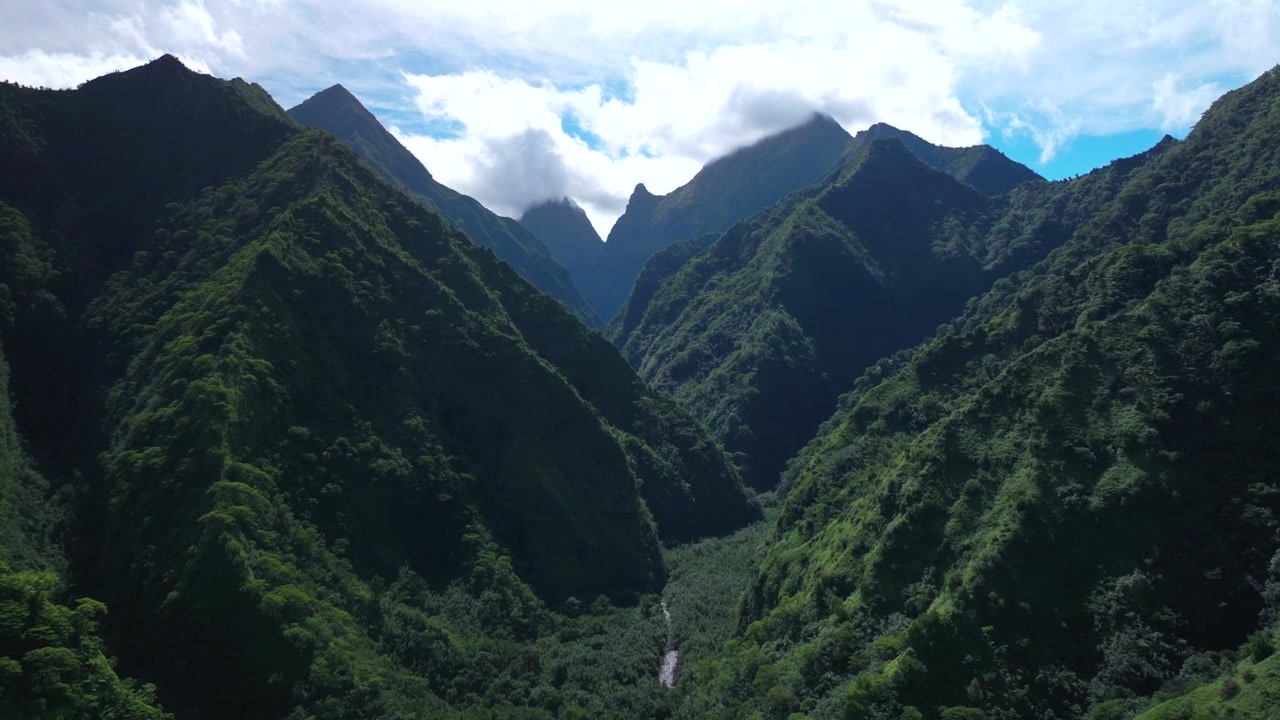 Bergsvulkaner i Teahupo'os landskap, Tahiti Franska Polynesien, flygfoto med drönare, regnperiod, solig morgon, blå himmel, moln över djungel, vulkanisk ås, Vaiauflodens dal, Mount Ronui, framåt uppåt