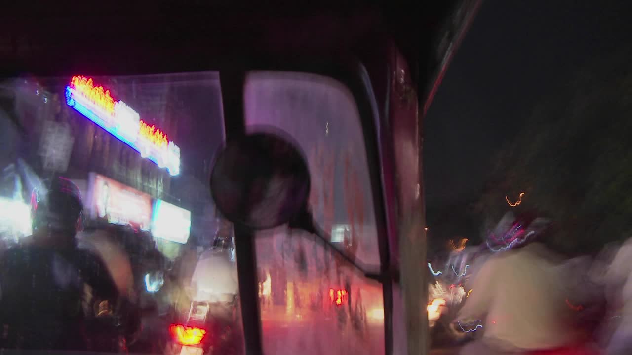 밤에 길을 운전하는 전동 인력거의 흐릿한 전망