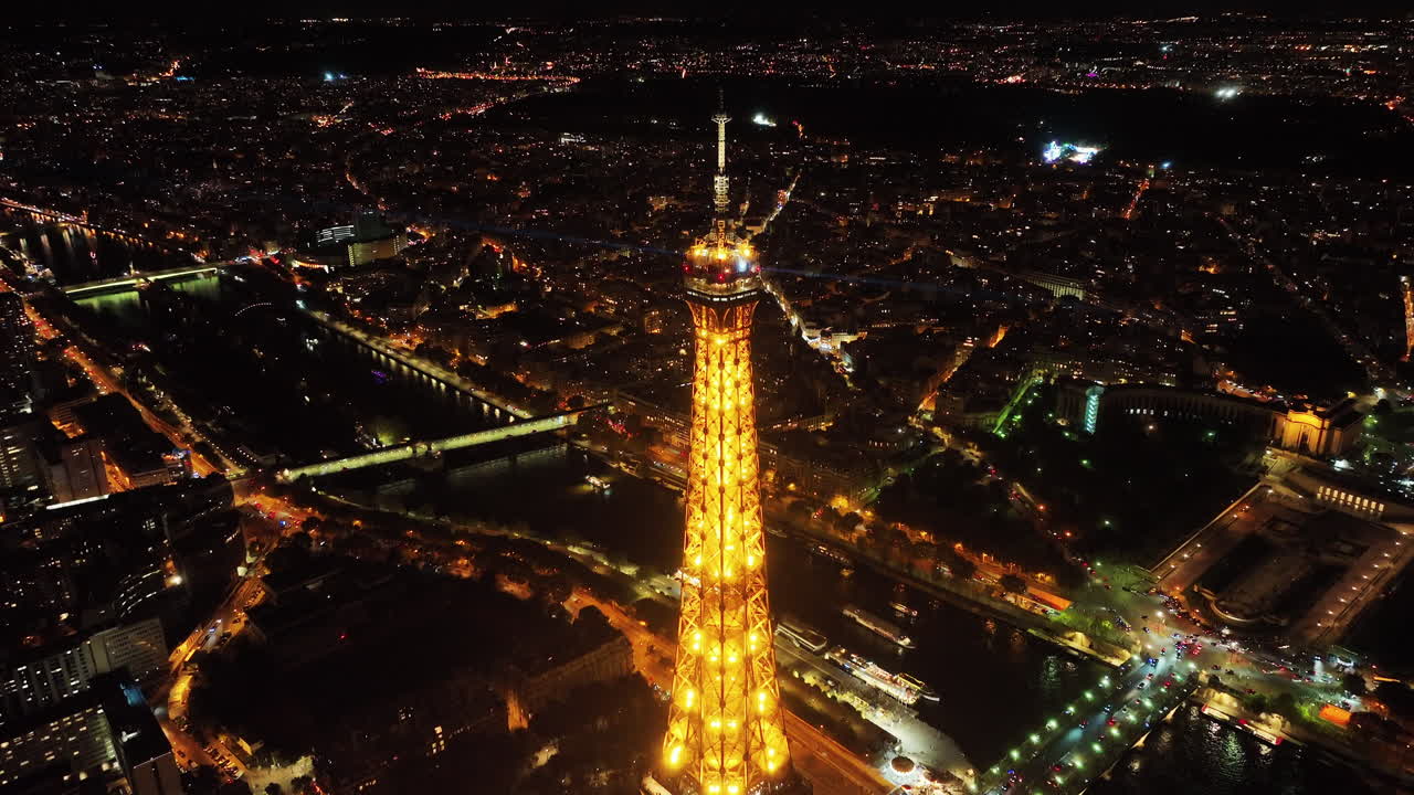 paralaje aéreo de la cumbre de la torre eiffel con rayos de luz brillando por la noche, vista panorámica del paisaje urbano de parís y los horizontes