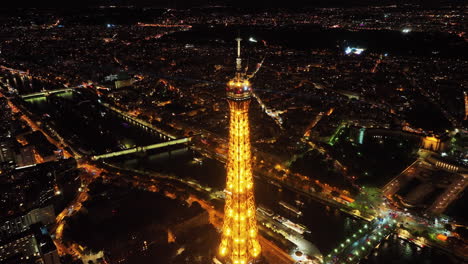 Luftparallaxe-Des-Eiffelturmgipfels-Mit-Nachts-Funkelnden-Lichtstrahlen,-Malerischer-Blick-Auf-Die-Pariser-Stadtlandschaft-Und-Die-Skylines