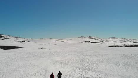 two cross country skiers entering the mountains, reveal mountains