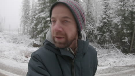 an extremely paranoid, frantic man walks along a snowy road, terrified of being followed