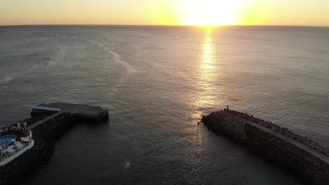 Aerial-View-Of-Golden-Yellow-Sunset-Over-The-Ocean-Water-Towards-Horizon