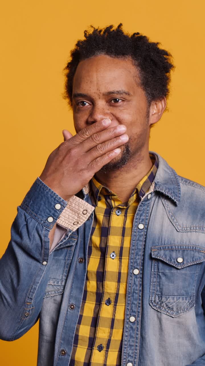 African American Man Covering Mouth and Smiling Playfully