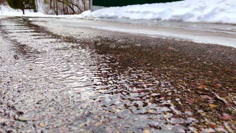 Nieve-Derritiéndose-Y-Fluyendo-Por-La-Calzada-De-Asfalto