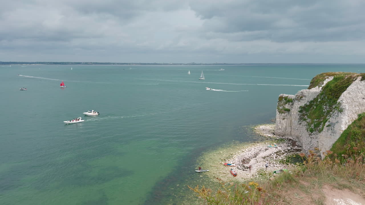 Boats Sailing In The Ocean Next To The Old Harry Rocks At Handfast Point, on the Isle of Purbeck in Dorset, England. - wide shot