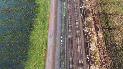 parallel railway tracks next to e45 in gothenburg, natural surroundings, daytime, aerial view