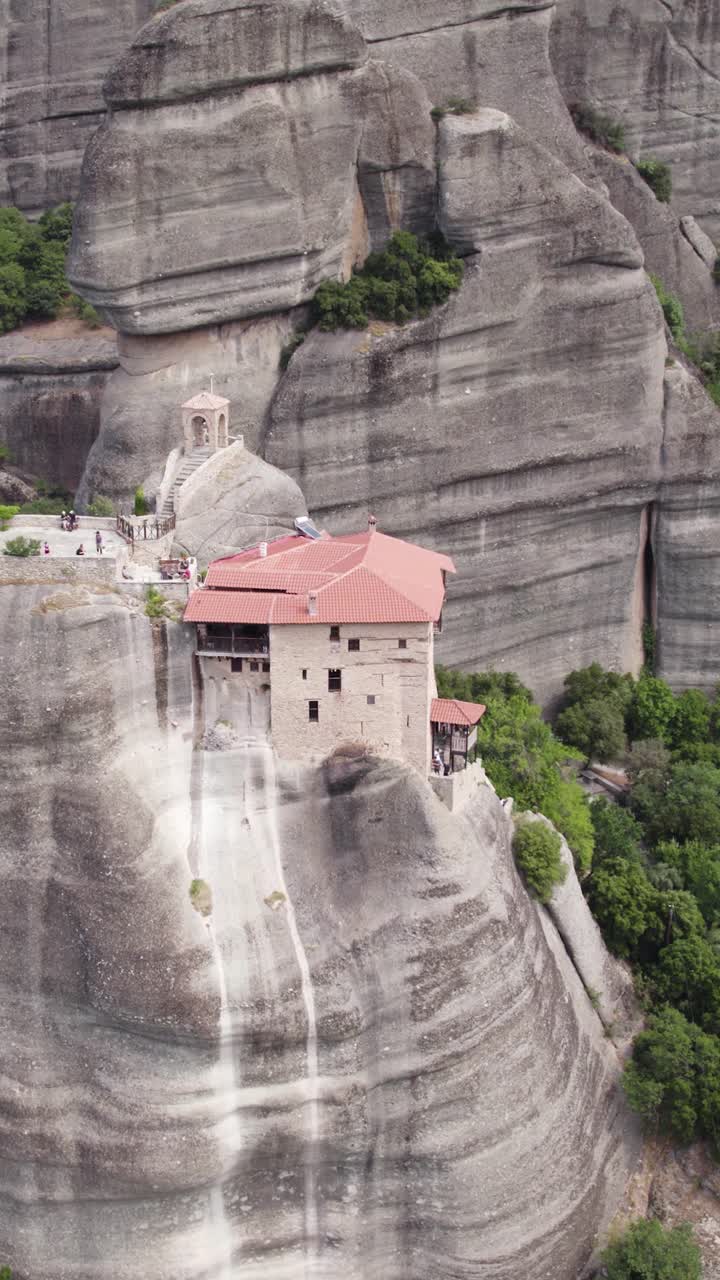 Vertical aerial view of the Holy Monastery of Saint Nicholas Anapafsas perched on a rocky precipice in Meteora, Greece