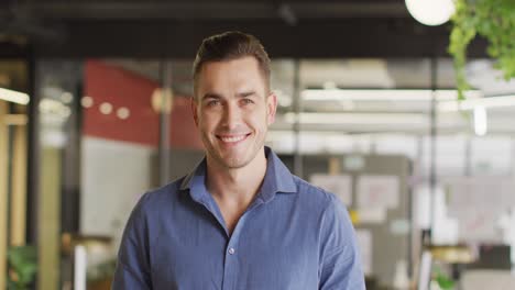 portrait of happy caucasian businessman looking at camera at office