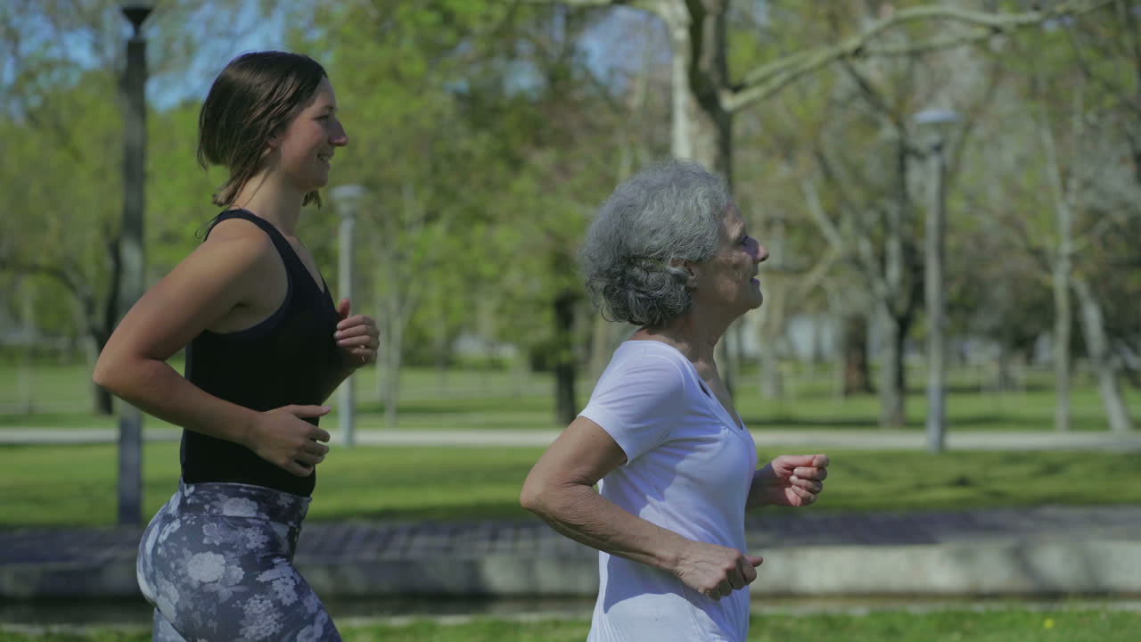 mujeres jóvenes y de mediana edad corriendo en el parque, una tras otra