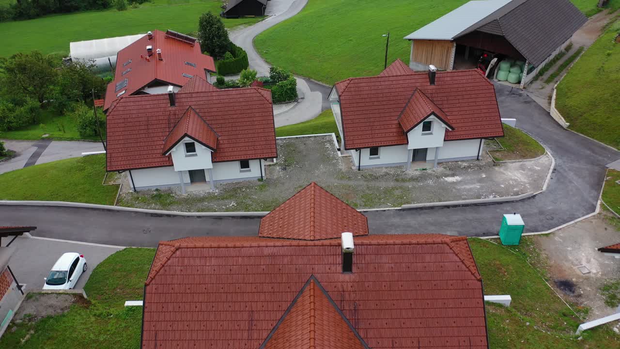 Drone aerial ascending tilt down bird eye view of a small village with cluster of houses