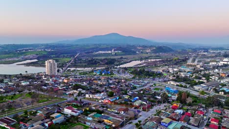 dolly in aerial view of a lower middle class neighborhood in concon, chile with the mauco hill in the background