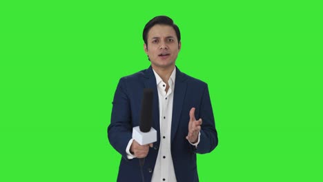 Fröhlicher-Indischer-Reporter,-Der-Fragen-Auf-Grünem-Bildschirm-Stellt