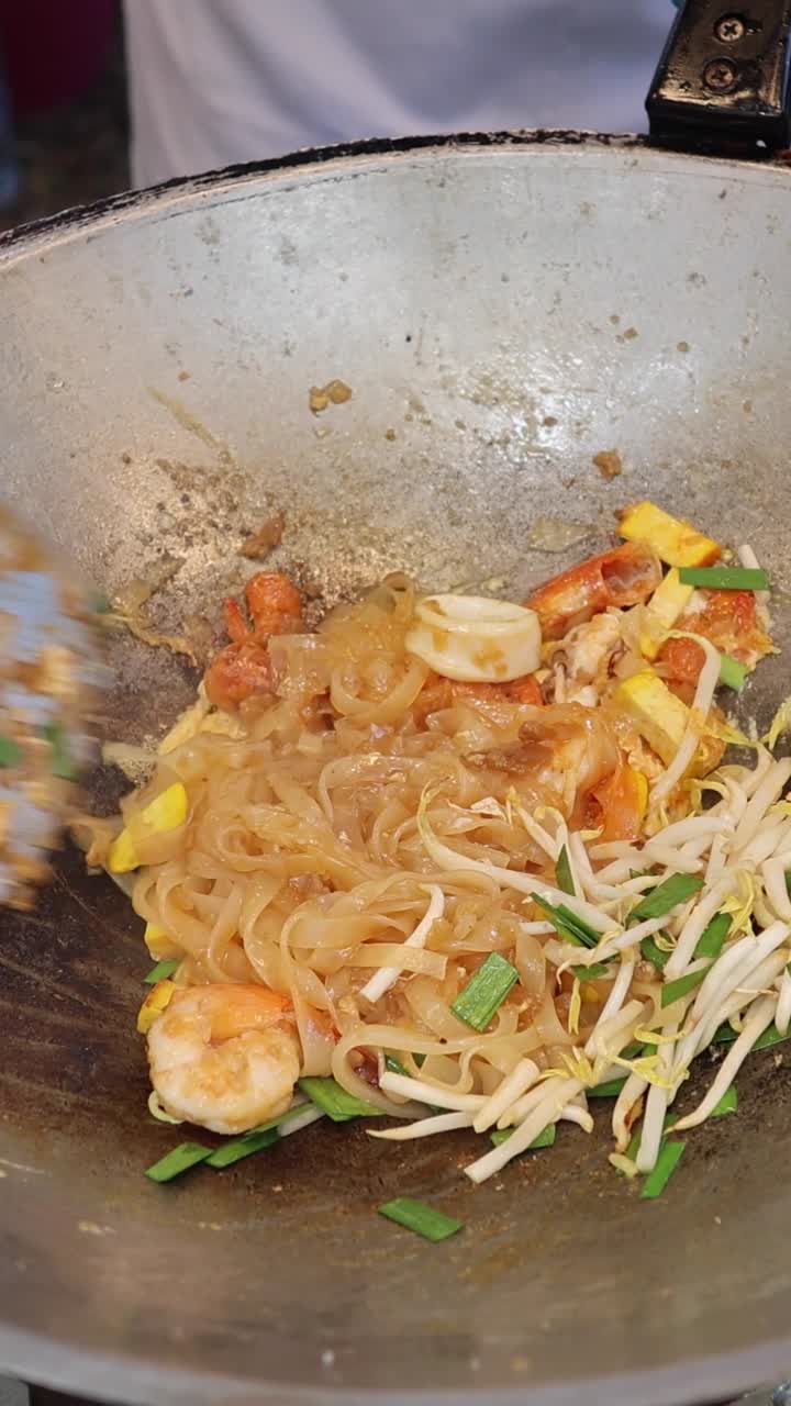 cocinando fideos con verduras y camarones.
