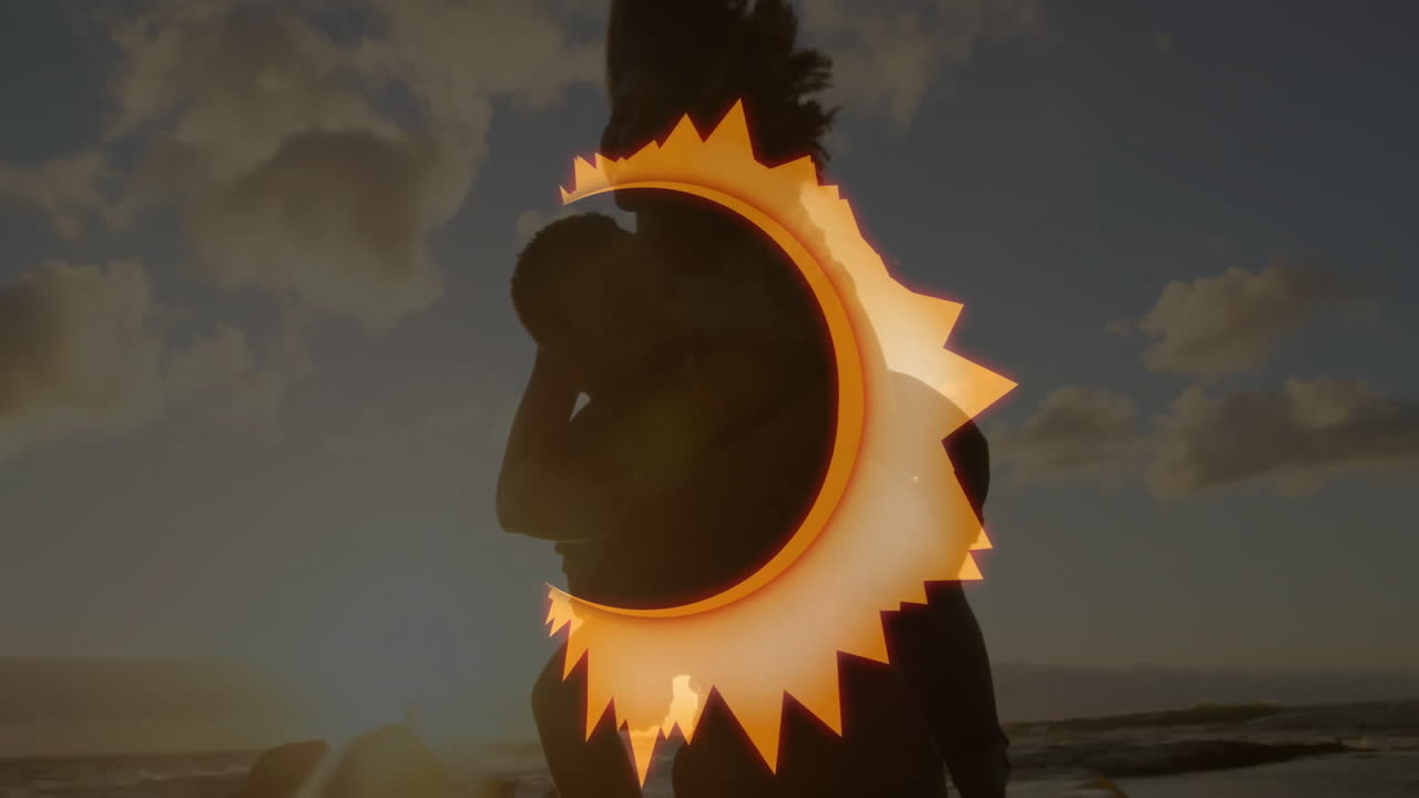 Silhouette of people at beach with glowing sun animation overlay