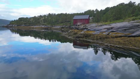 red fishermans cabin rorbuer at fjord in nordland, norway - aerial 4k